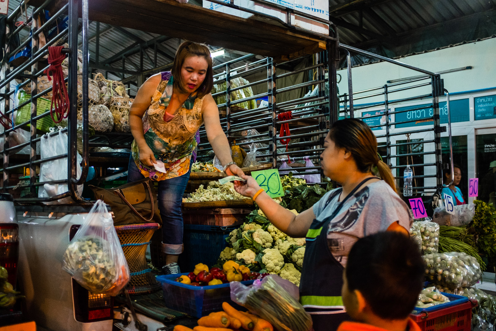 Woman on back of truck selling vegetables